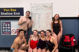 Swimmers at Aberystwyth University next to a whiteboard with their distances